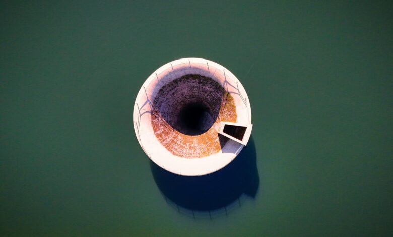 Aerial view of a large water reservoir with concrete dam structure