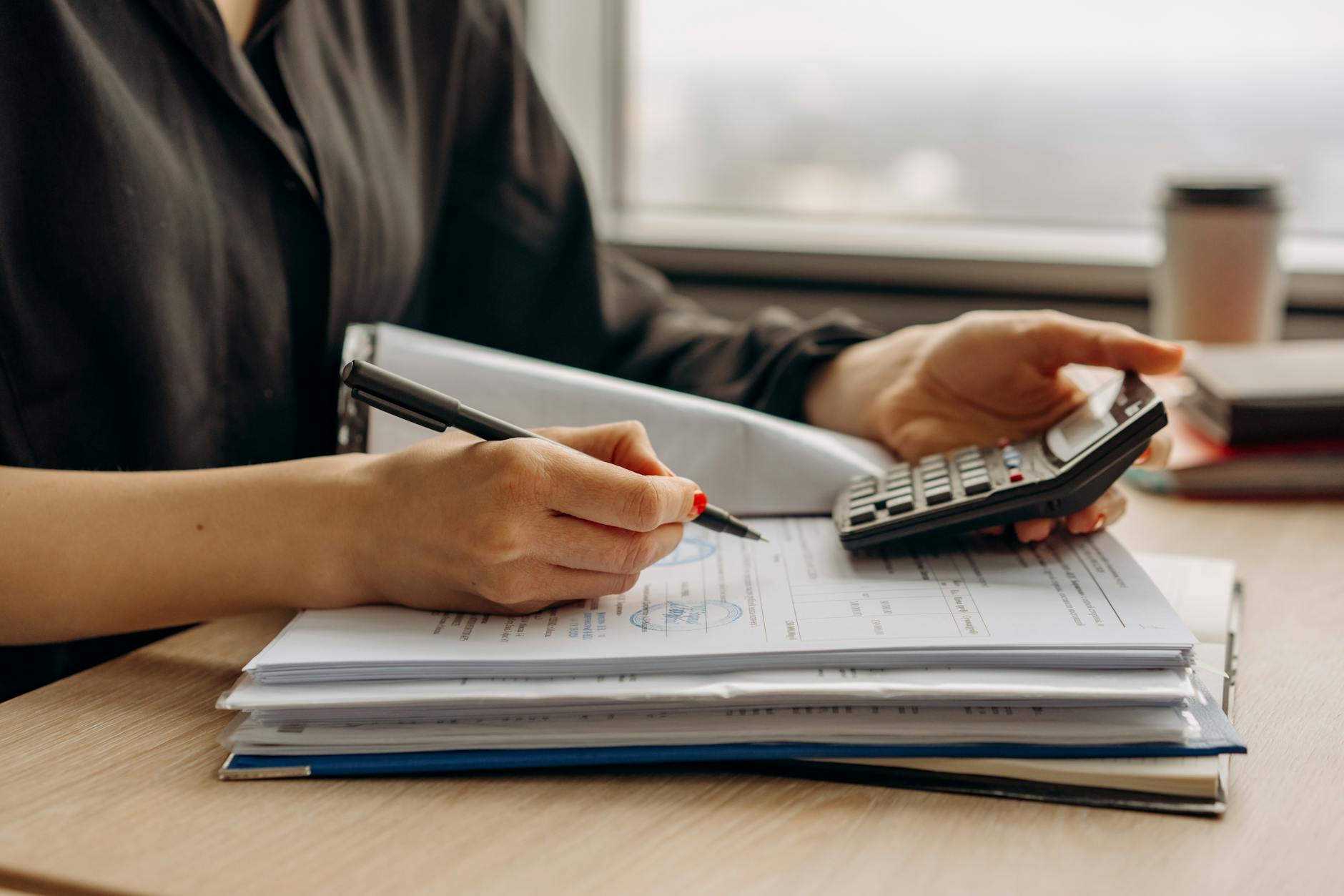 Calculator and financial documents on desk representing loan payment calculations