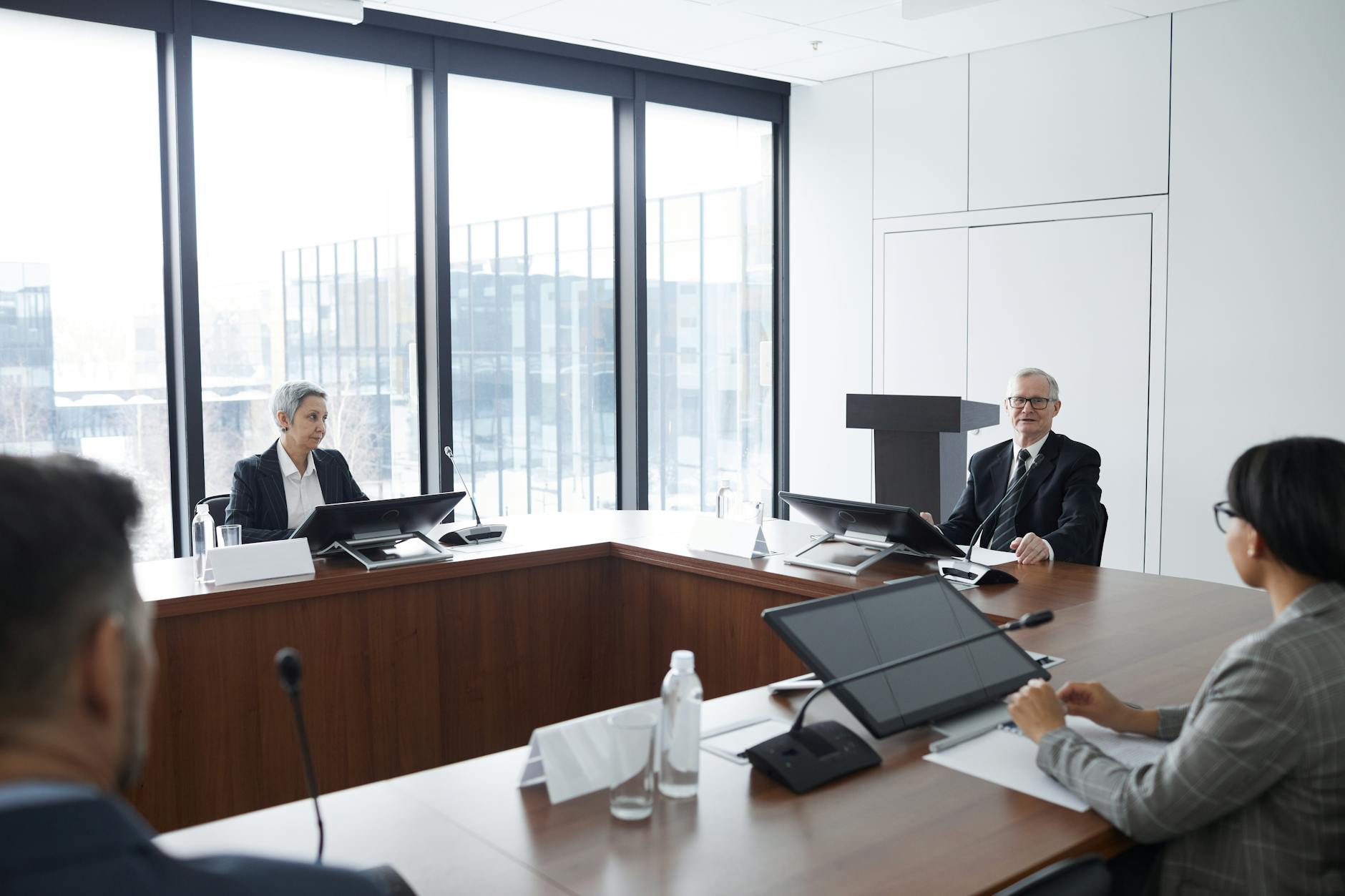 Professional business meeting in modern conference room with people discussing investment strategies