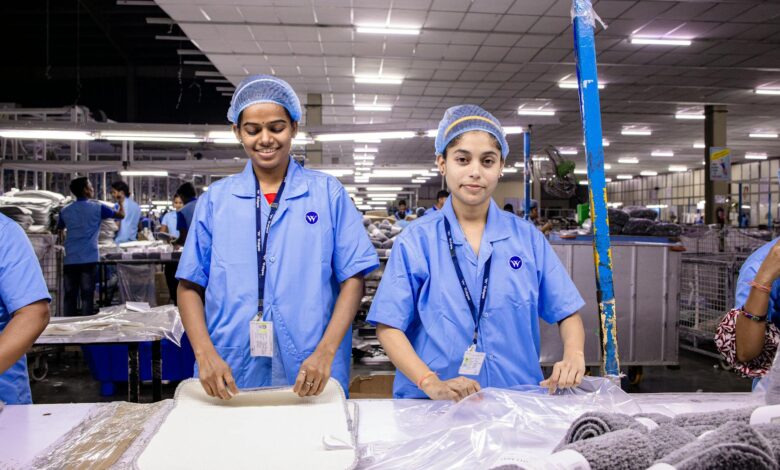 Manufacturing workers operating modern industrial equipment in a clean factory environment