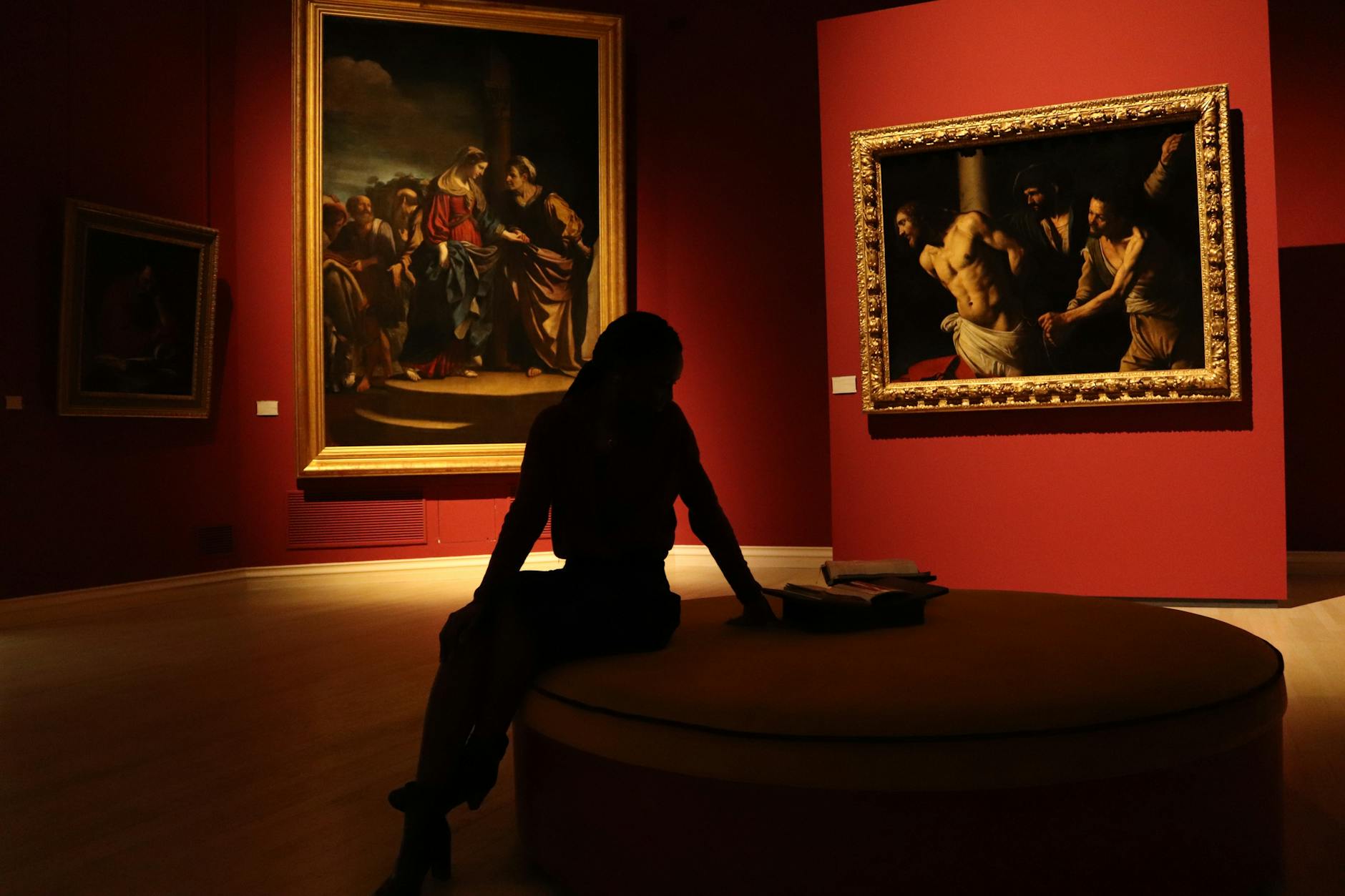Modern gallery space with white walls and professional lighting displaying framed artwork