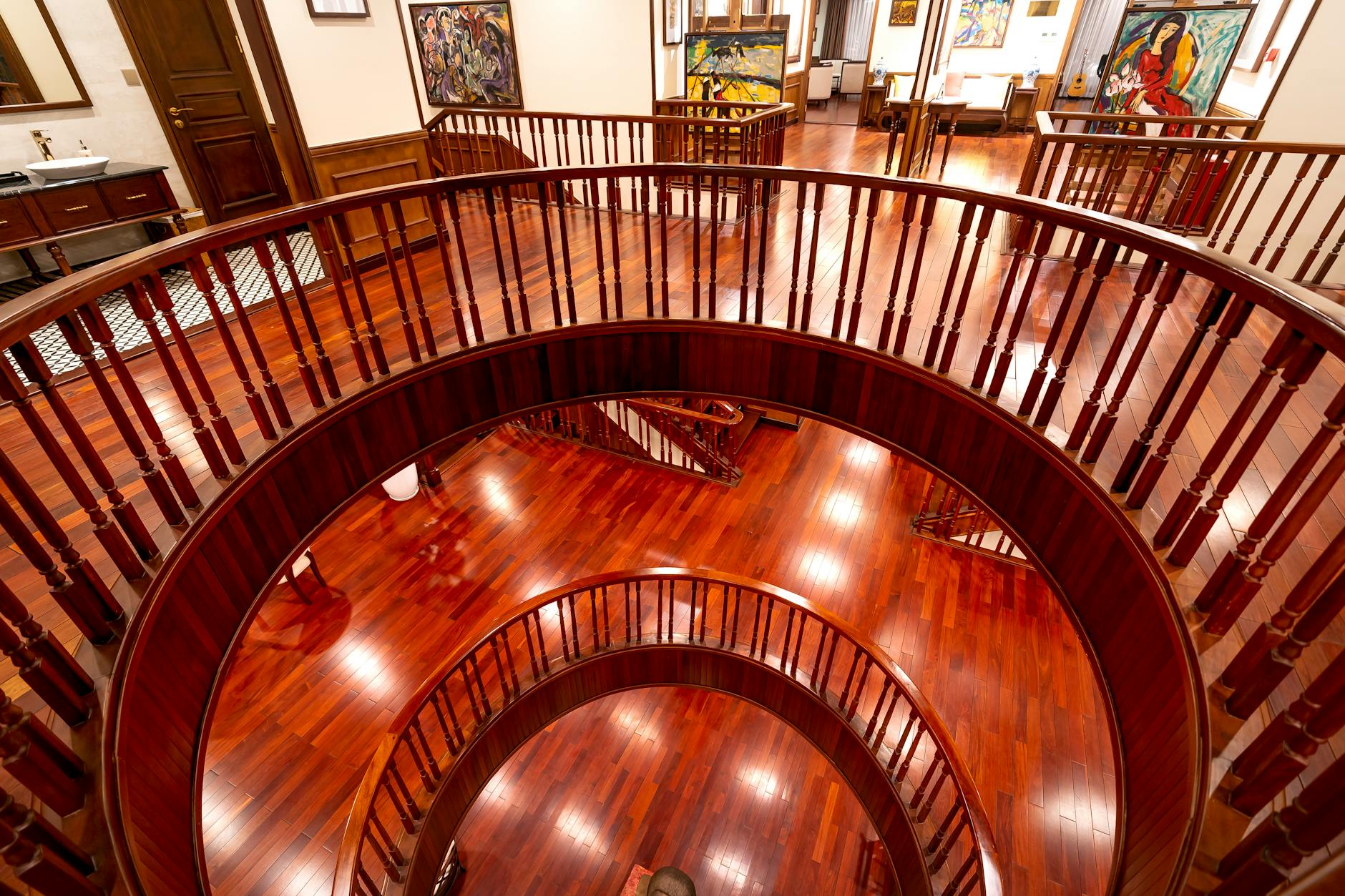 Elegant art gallery interior with paintings displayed on white walls under professional lighting