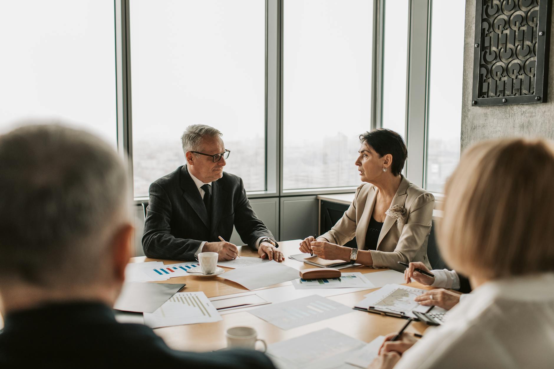 Professional business meeting with documents and laptops on conference table