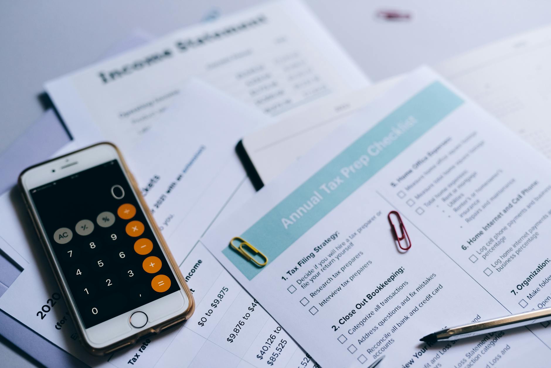 Financial planning documents and calculator showing tax calculation and investment analysis