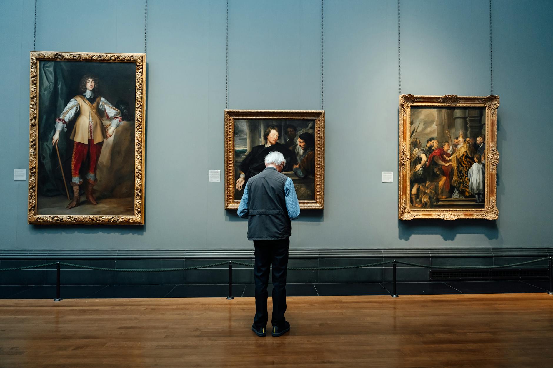 Contemporary art gallery space with paintings displayed on white walls under professional lighting