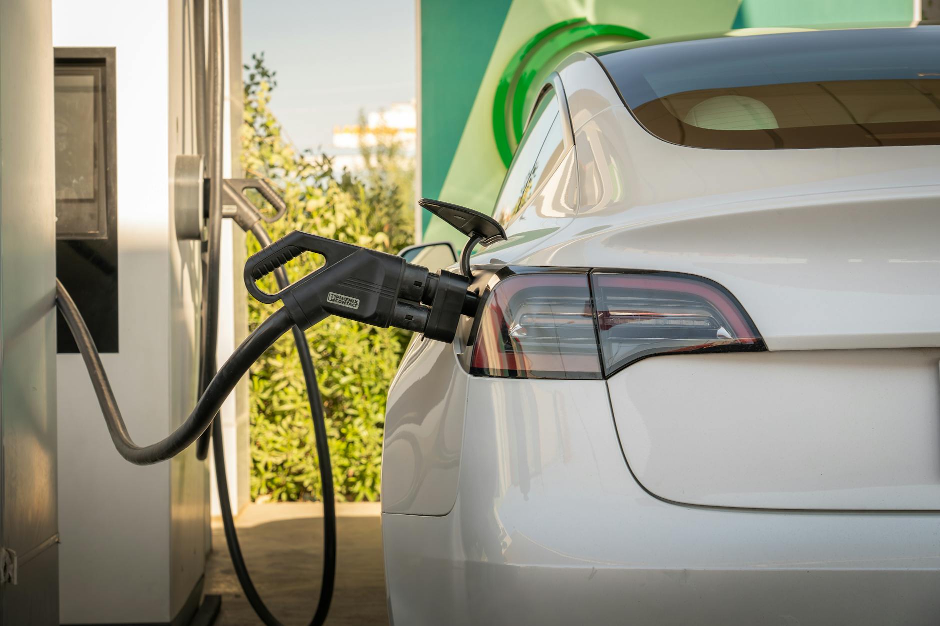Electric vehicle connected to charging station demonstrating growing EV adoption