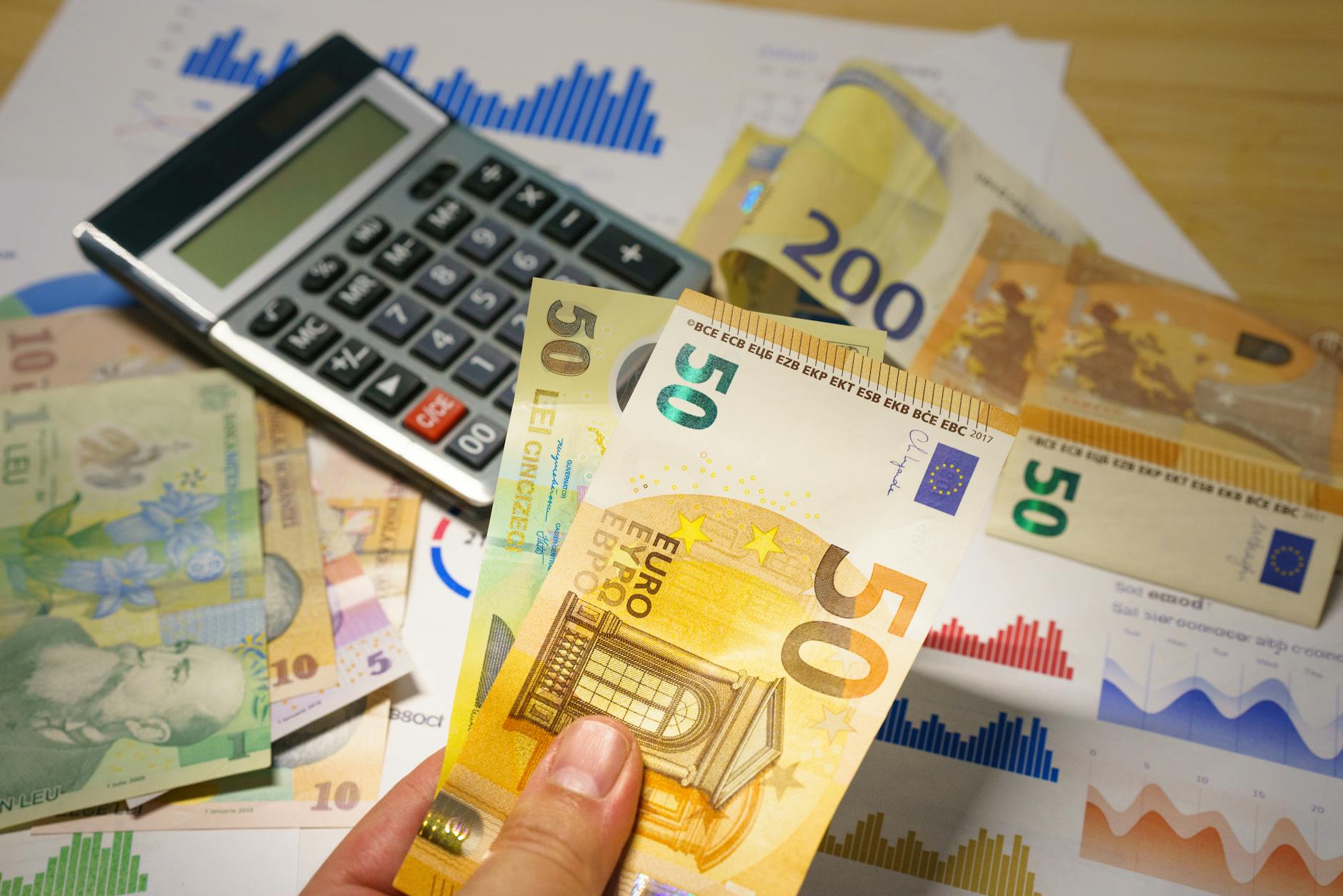 Financial calculator with money and investment charts showing portfolio analysis