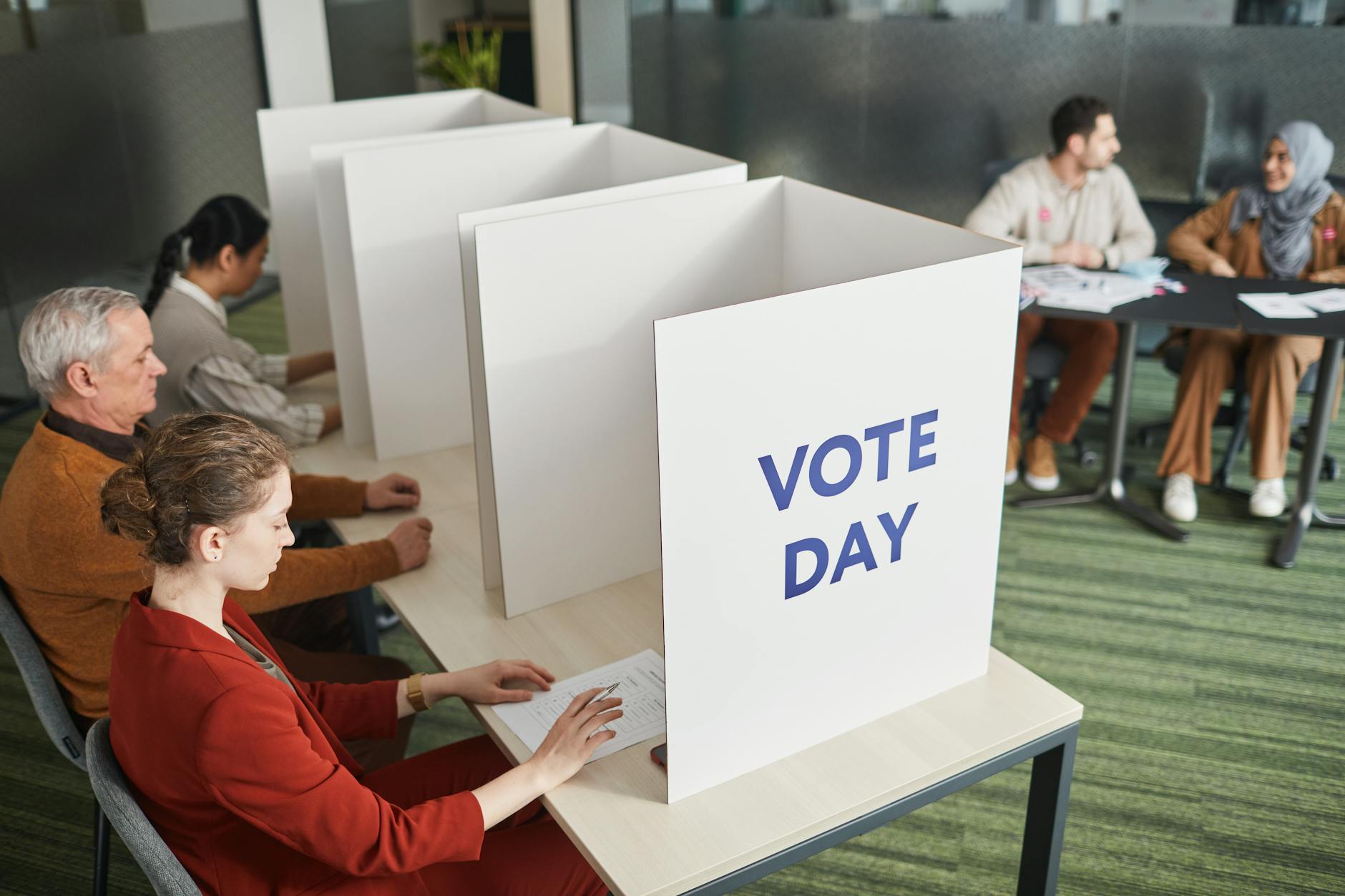 Person casting ballot in voting booth during election