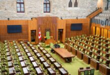 Empty state legislative chamber with rows of seats and a podium at the front