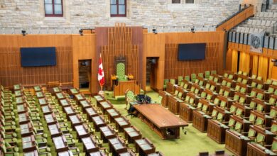 Empty state legislative chamber with rows of seats and a podium at the front