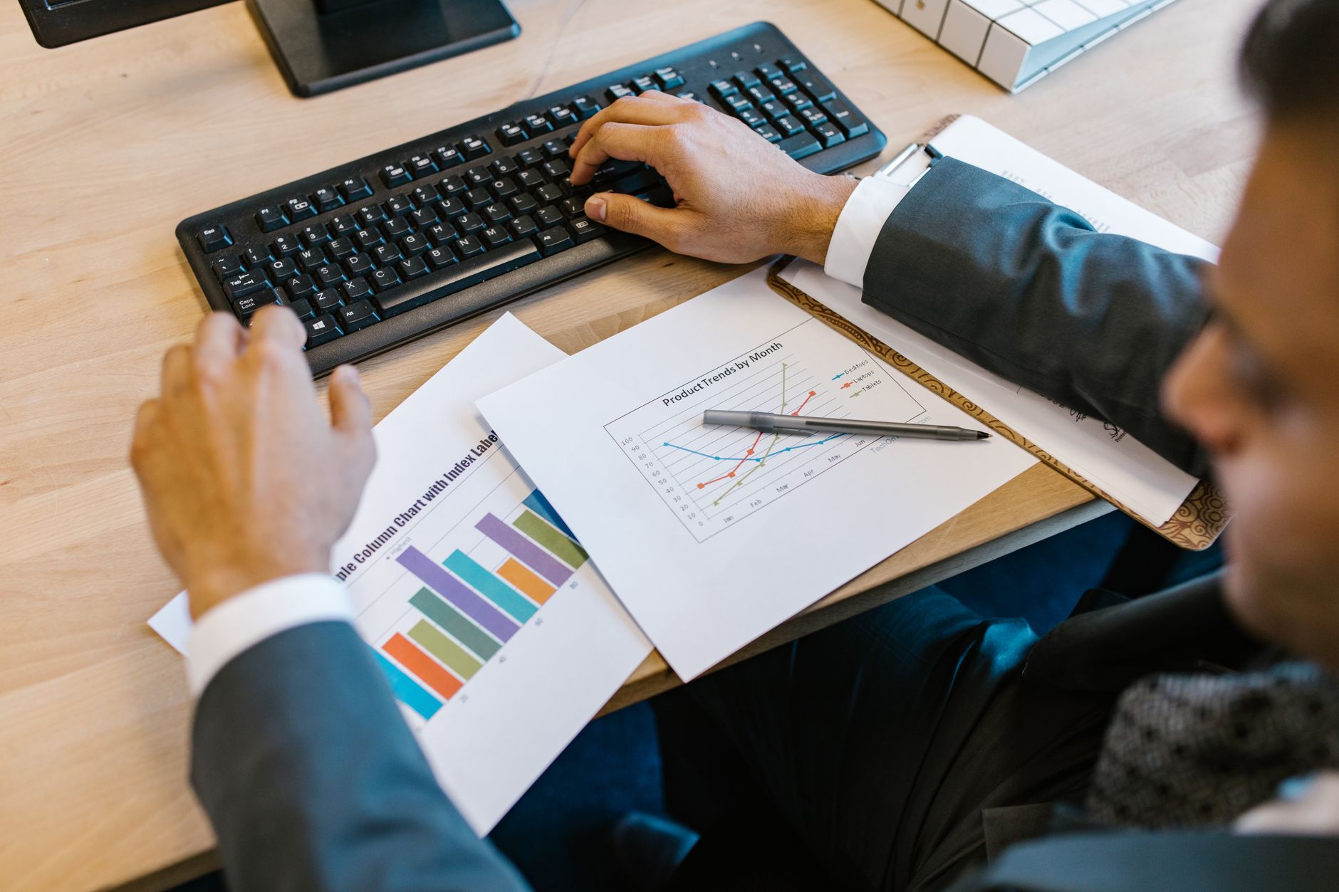 Financial charts and investment documents spread across a desk