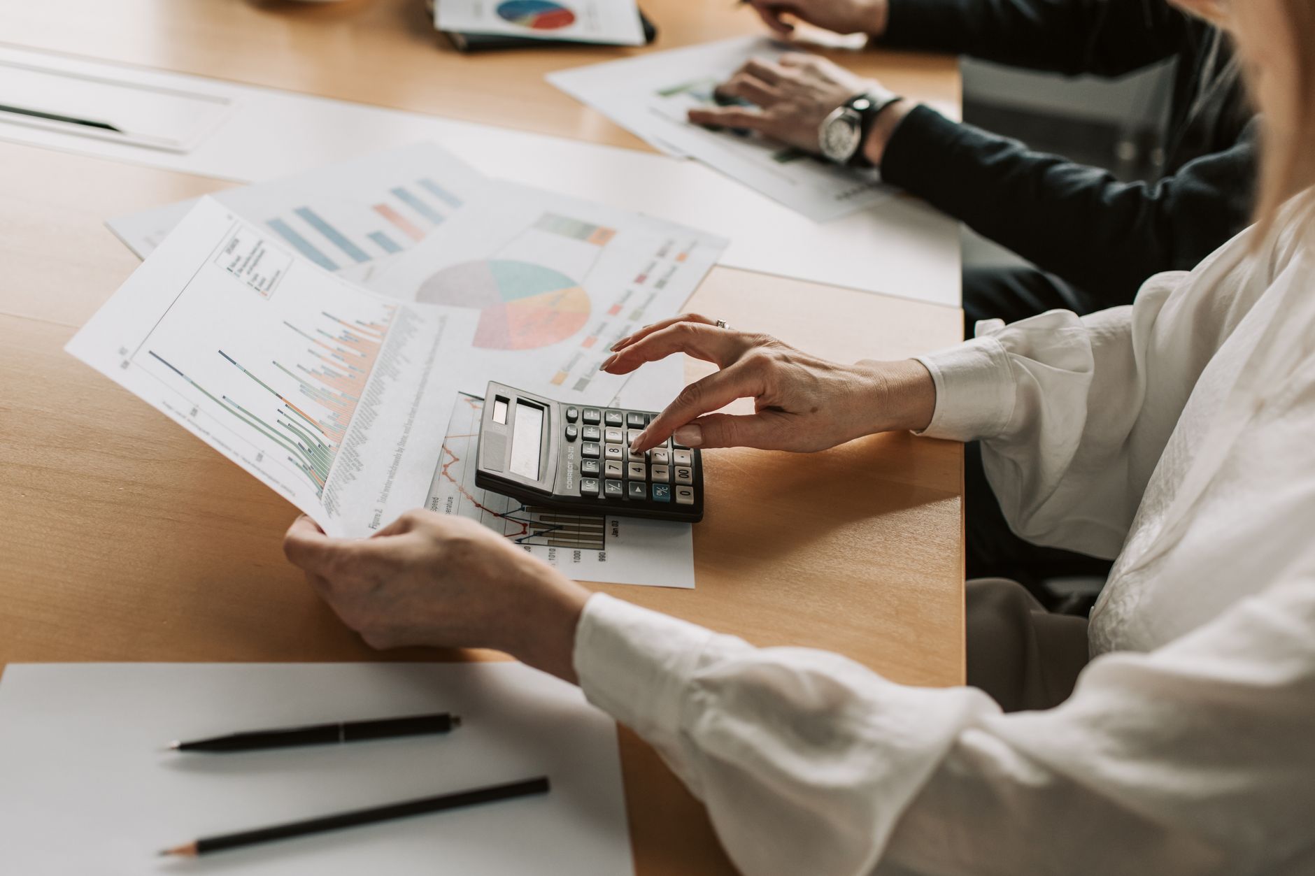 Investment committee professionals reviewing portfolio allocation documents in a formal meeting