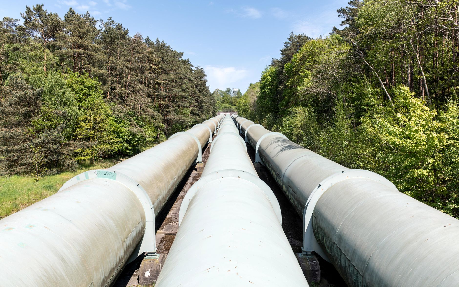 Industrial energy pipeline running through a coastal facility at dusk