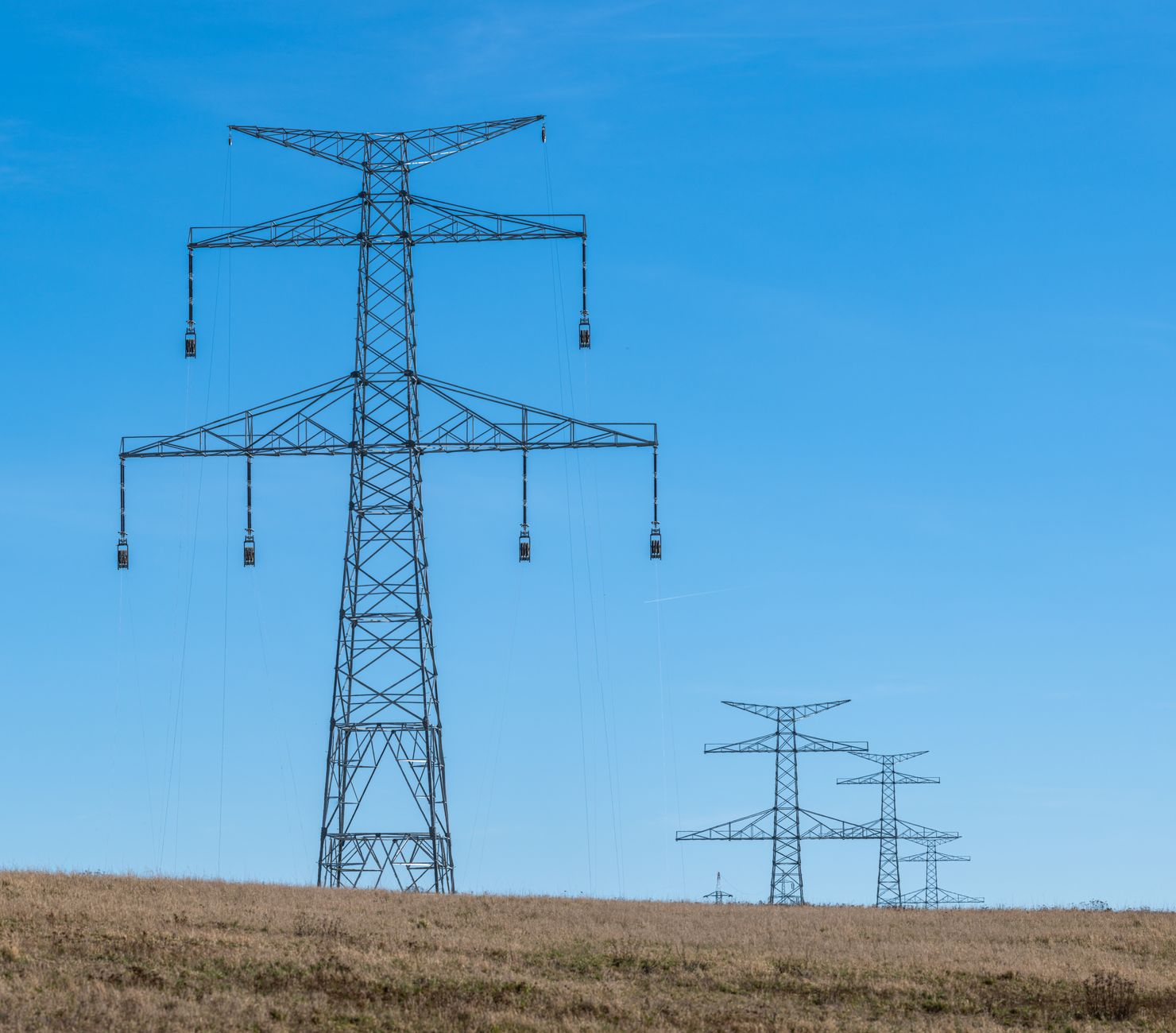 High-voltage electricity transmission lines representing regulated infrastructure assets in debt financing