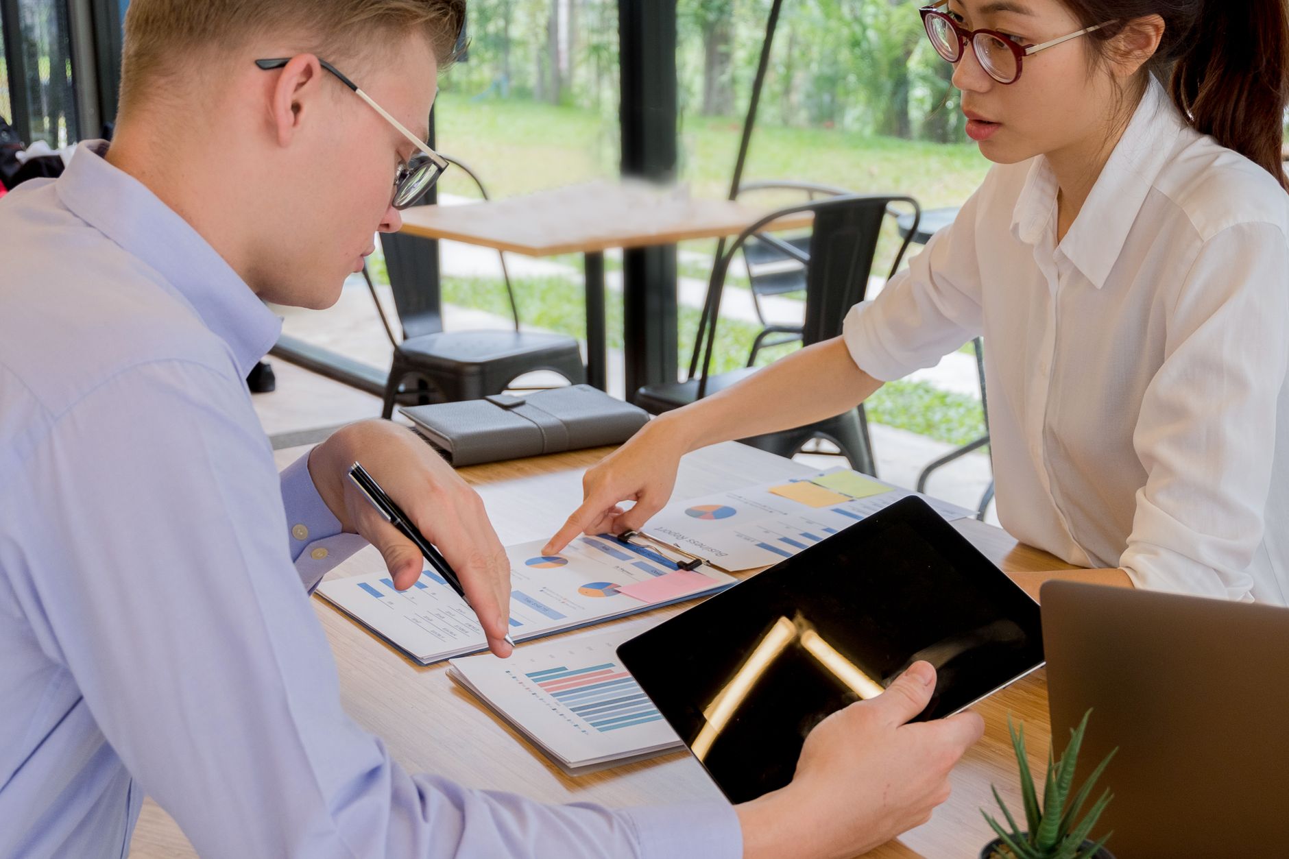 Professionals reviewing investment documents in a formal meeting setting