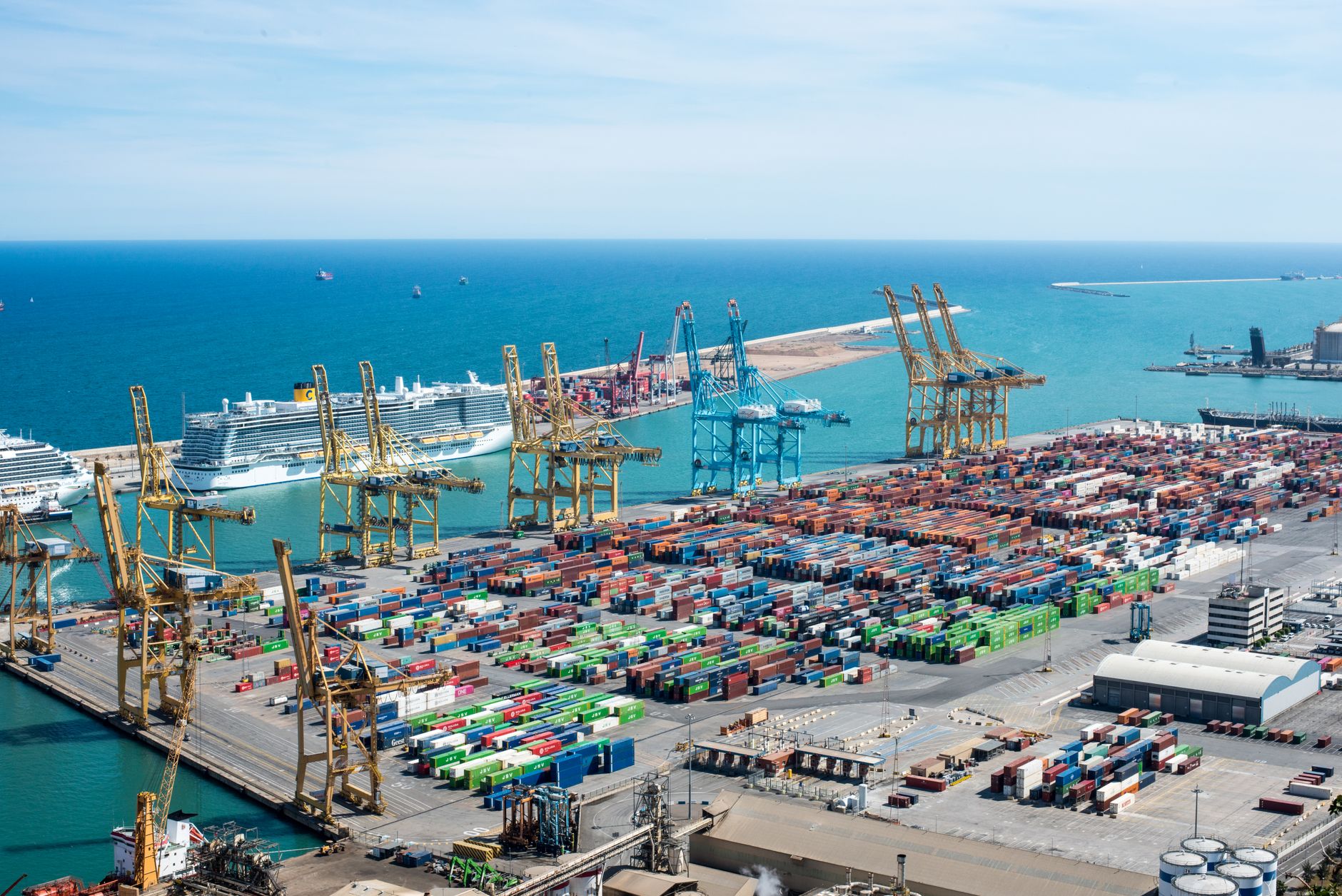 Aerial view of a large commercial seaport with container ships and loading cranes