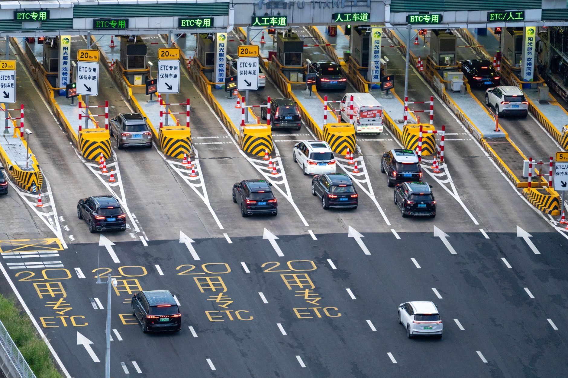 Aerial view of a multi-lane toll road with traffic flowing through payment booths