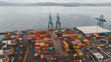 Aerial view of a large commercial seaport with container ships and loading cranes