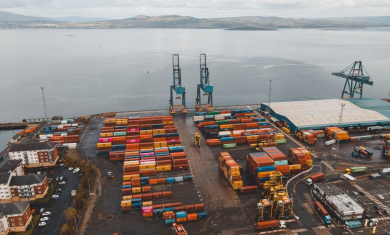 Aerial view of a large commercial seaport with container ships and loading cranes