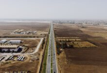 Aerial view of a multi-lane toll expressway with traffic flowing through toll booths