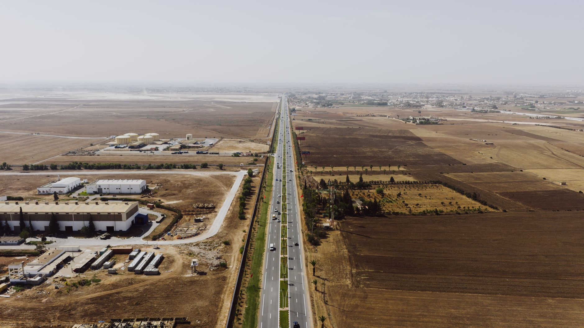 Aerial view of a multi-lane toll expressway with traffic flowing through toll booths