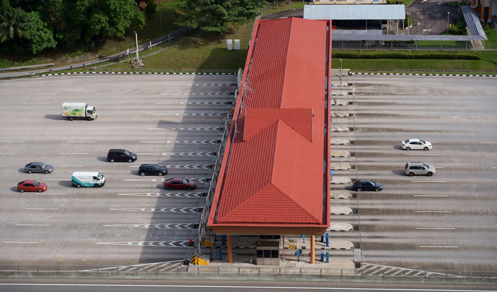 Aerial view of a multi-lane toll road cutting through open landscape