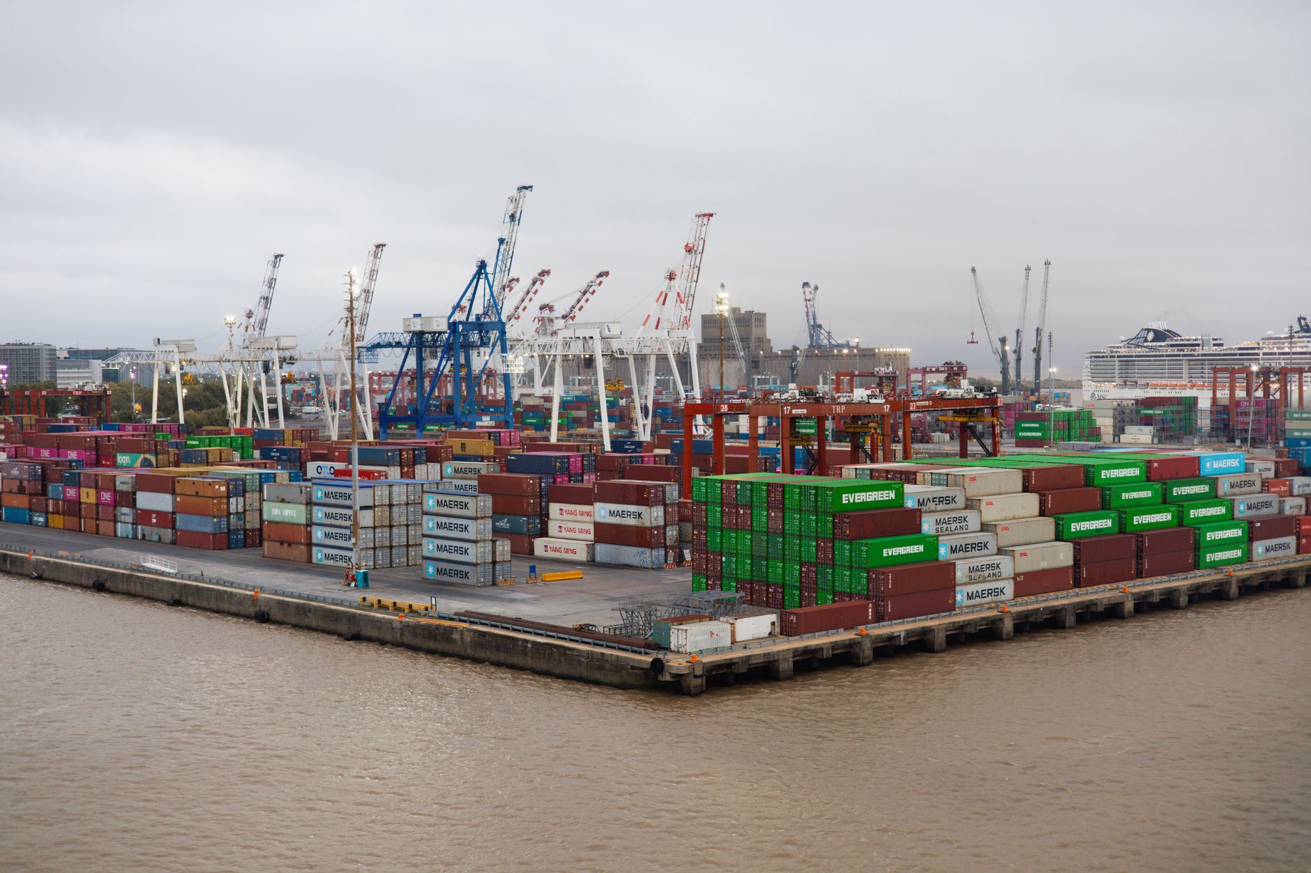 Shipping containers stacked at a busy commercial port terminal