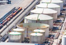 Large aviation fuel storage tanks near a commercial airport runway