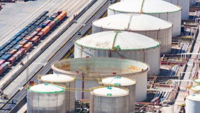Large aviation fuel storage tanks near a commercial airport runway