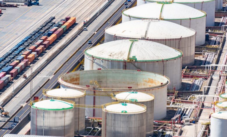 Large aviation fuel storage tanks near a commercial airport runway
