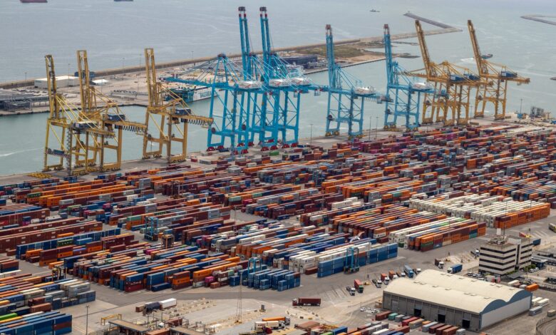 Aerial view of a busy seaport with container ships and docking infrastructure