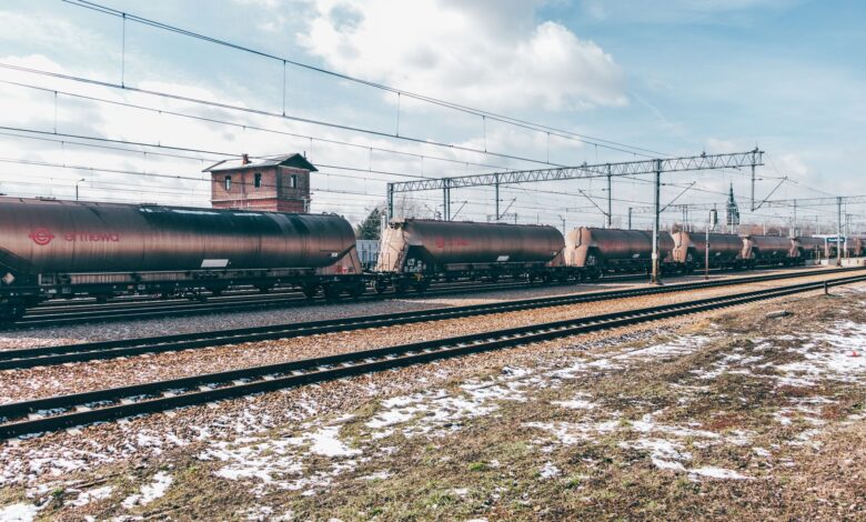 Long freight train moving along rail tracks through open countryside
