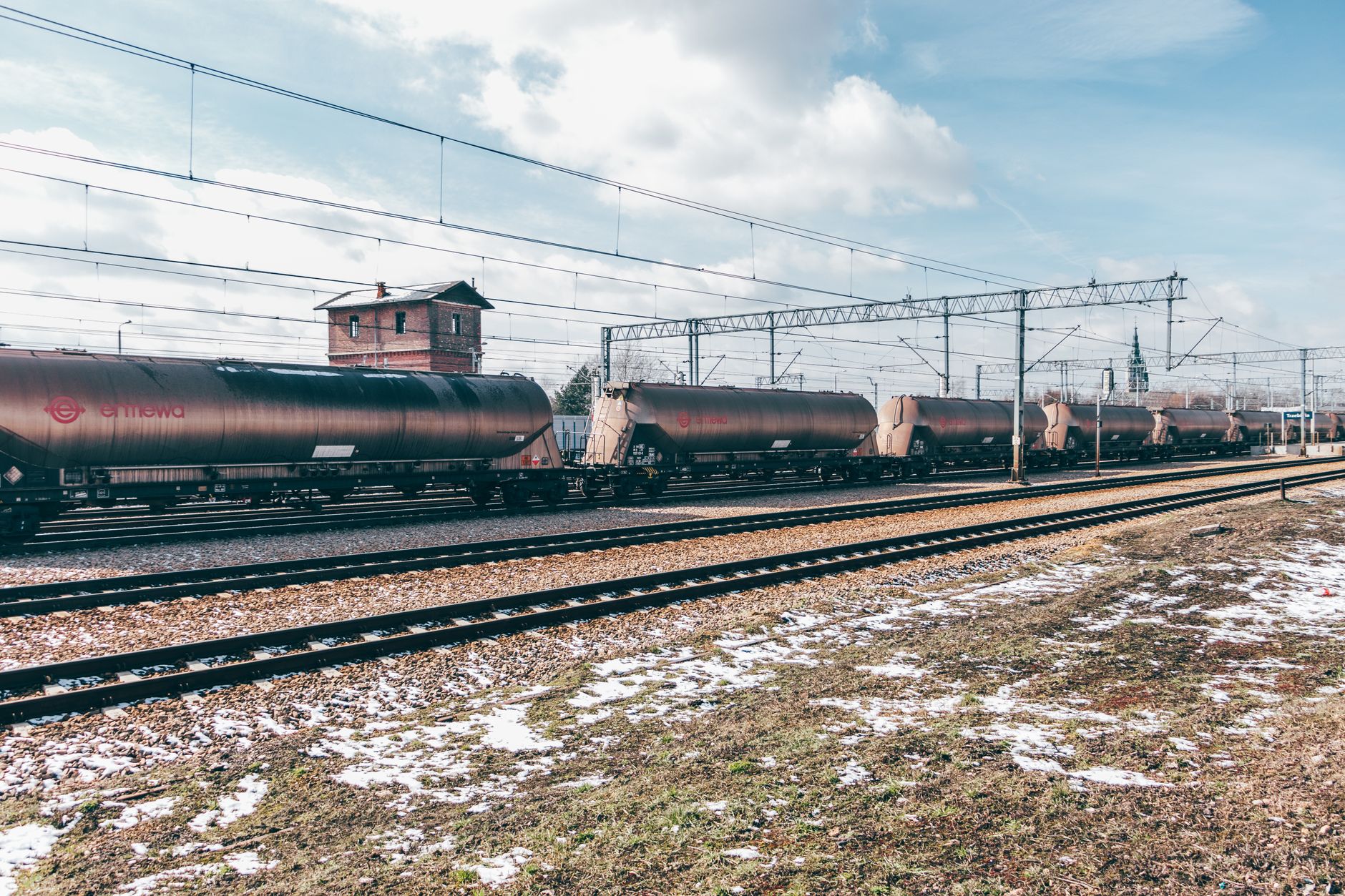 Long freight train moving along rail tracks through open countryside