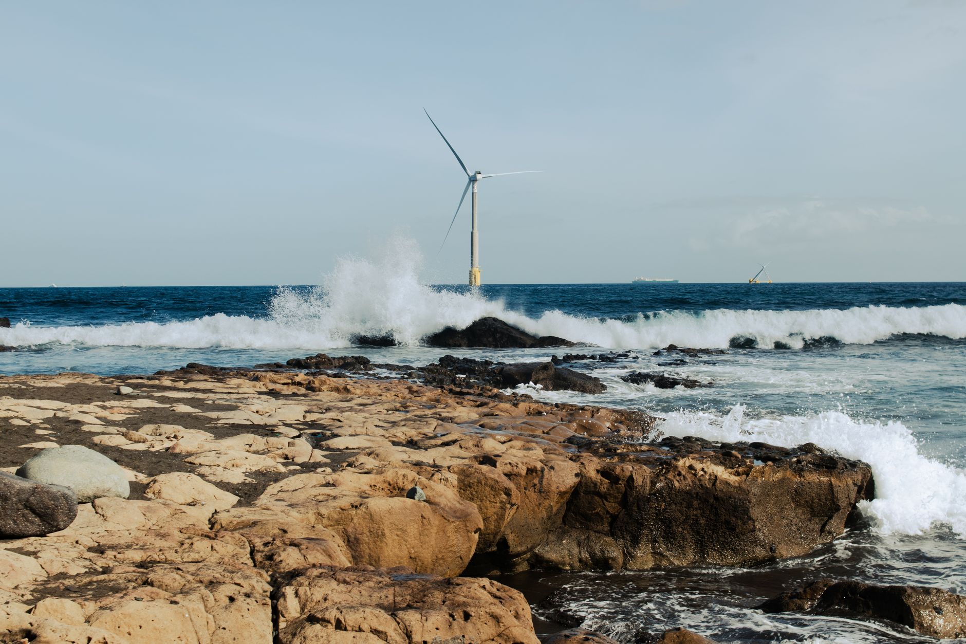 Offshore wind turbines standing in open ocean waters at dusk