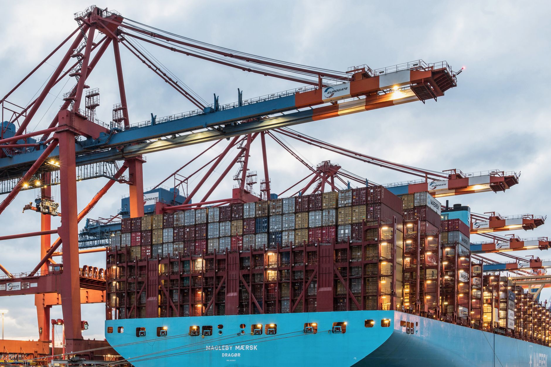 Rows of colorful shipping containers stacked at a busy port terminal