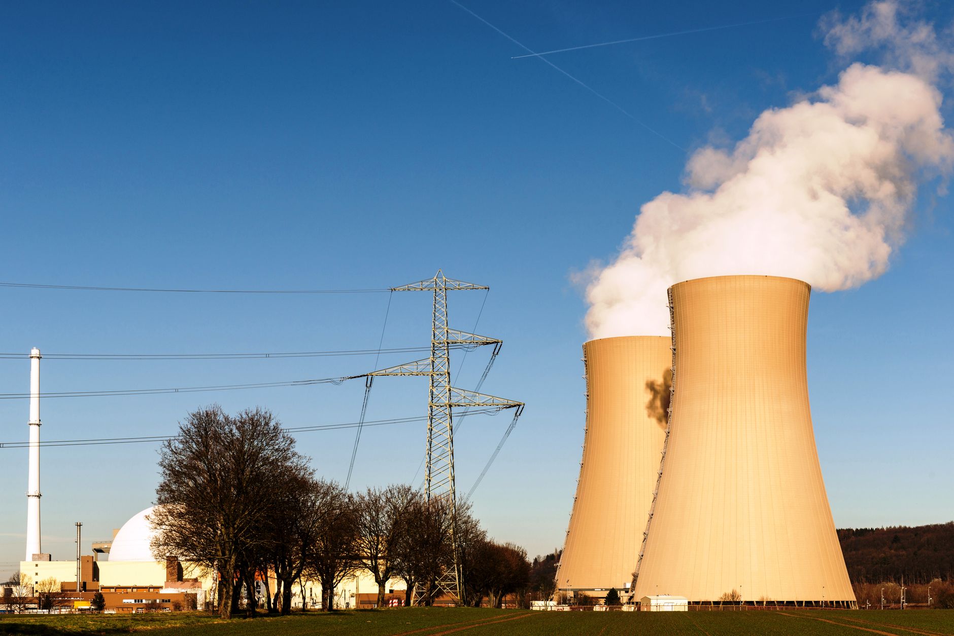Nuclear power plant cooling towers reflected in still water at dusk