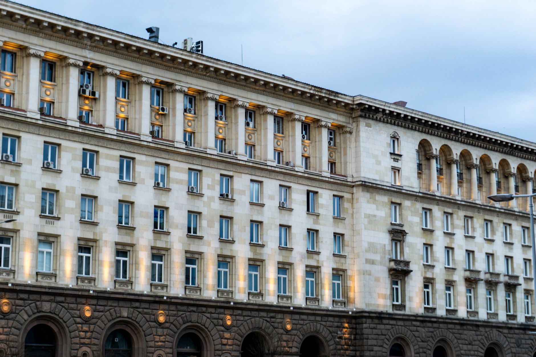 Exterior of a government or regulatory building with columns and flags