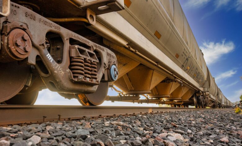 A row of freight railcars on an industrial rail line