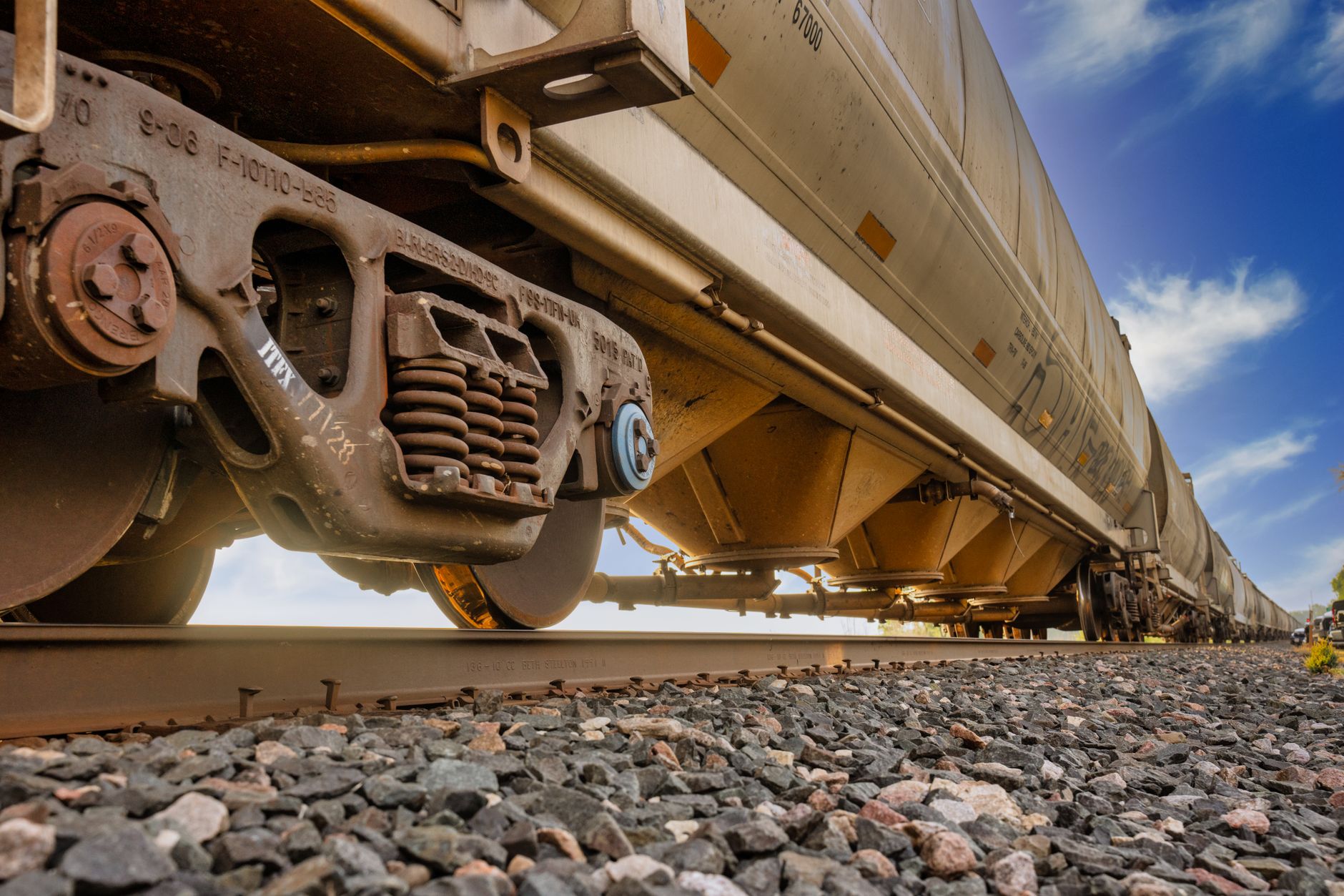 A row of freight railcars on an industrial rail line