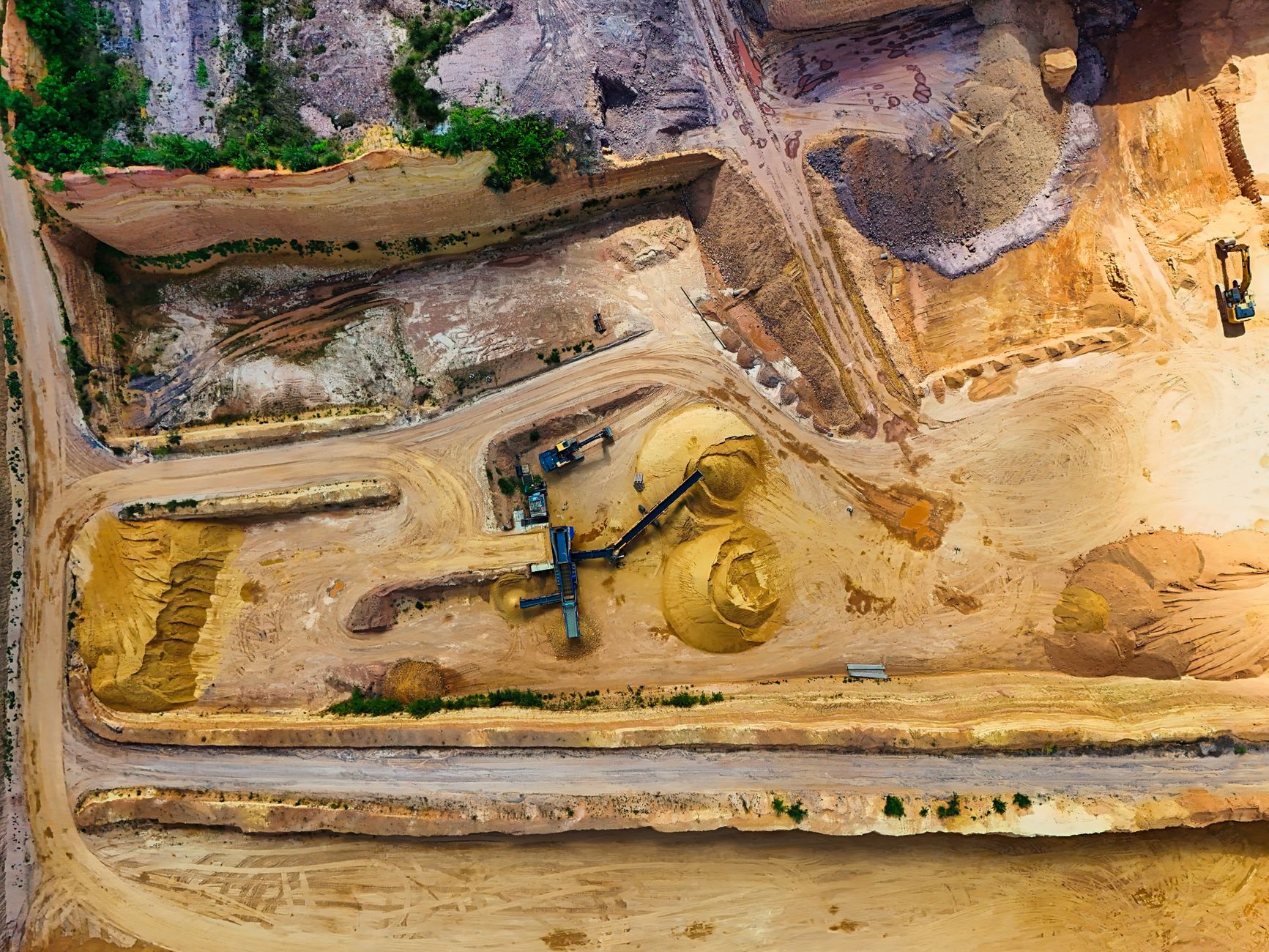 Aerial view of an open gravel quarry pit with extraction equipment