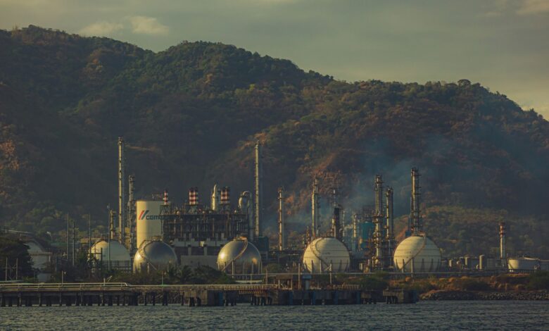Large industrial oil refinery with processing towers and pipeline infrastructure