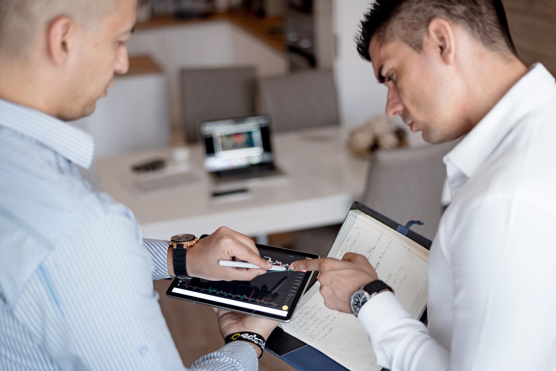 Two professionals reviewing documents in a private investment meeting